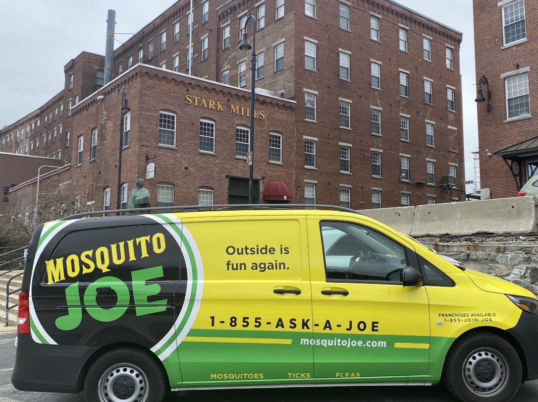 Mosquito Joe of Manchester-Souhegan Valley yellow and green truck in front of Stark Mills building located in Manchester, NH